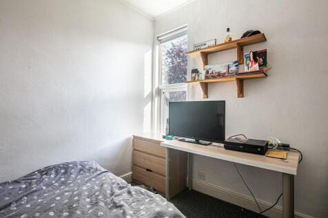 Bright, simply furnished bedroom with a single ...
