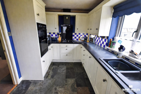Modern L-shaped kitchen with slate floors.png