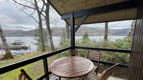 Covered Lodge Decking With Outdoor Dining And Loch