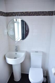 A modern, clean bathroom featuring a white sink...