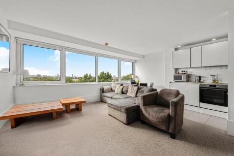 The 6th-floor apartment includes an open-plan living area with a fully integrated modern kitchen, a modern bathroom, a separate laundry room, and two large equally sized double bedrooms with plenty of