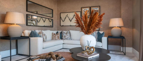 Modern living room with beige patterned wallpaper, white sofa, colourful cushions, side tables with