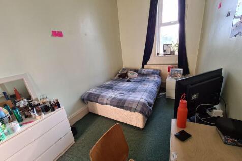 A cozy single bedroom with a bed positioned nea...