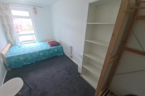 A cozy single bedroom featuring a comfortable b...