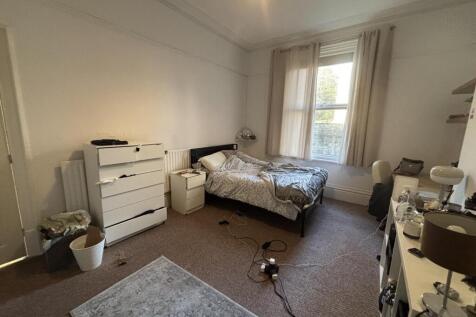 Bright, neatly arranged double bedroom with a c...