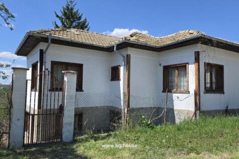 White house with metal gate entrance and garden area in Dolets village
