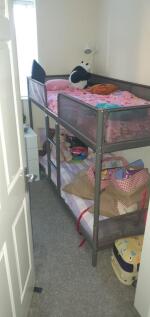 Compact bedroom with metal bunk beds dressed in...