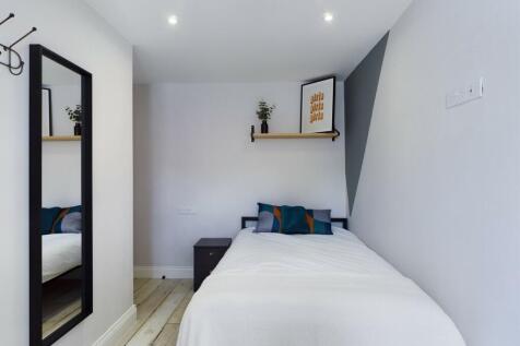 A bright and inviting single bedroom featuring ...