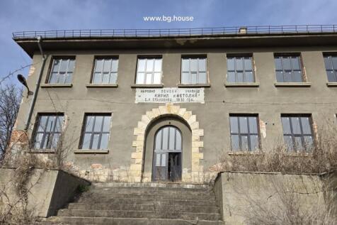 Detailed view of the main entrance with stone arch and steps leading up