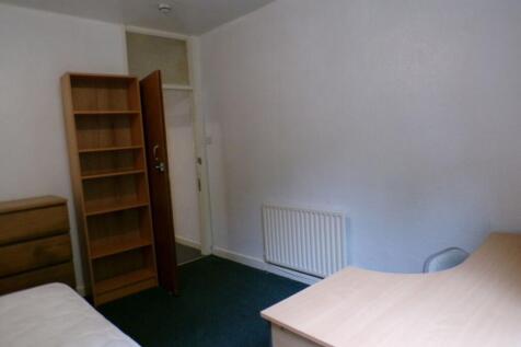 Simple furnished bedroom with a desk, shelving ...