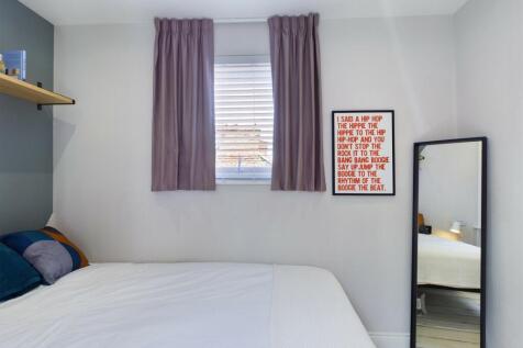 A neatly presented bedroom featuring a large be...