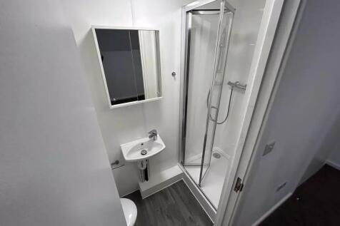 Bright, modern bathroom with a corner shower en...