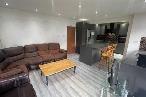 Bright, open-plan living area with a large L-sh...