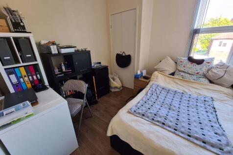 Cozy single bedroom featuring a comfortable bed...