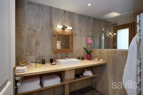 A modern bathroom with wooden accents, featuring a