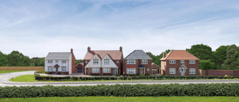 Row of modern detached houses with varied designs, set along a curved street under a clear blue sky