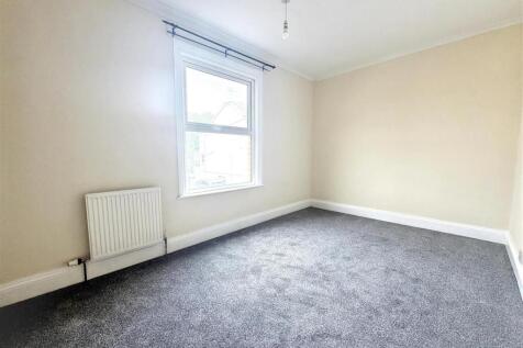 Bright, newly carpeted bedroom with large windo...