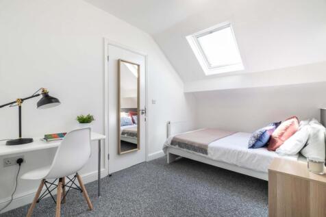 A bright and tidy single bedroom featuring a co...