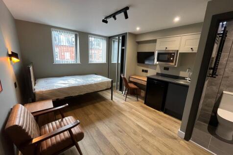 Bright, modern studio-style room with a comfort...