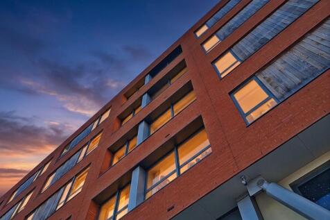 Modern one-bedroom apartment with open plan living, sleek kitchen, wood floors, stylish bathroom, utility area, and access to a communal decked area. Bright, airy, and well-designed throughout.