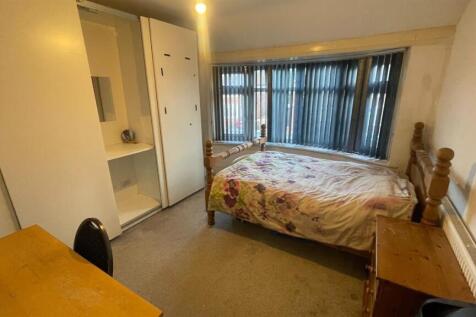 Bright double bedroom with a large window, buil...
