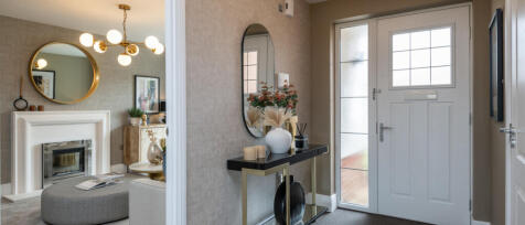 Modern interior hallway with a black console table, decorative vase, mirror, and front door with fro