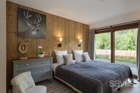 Cozy bedroom with a wooden accent wall, featuring 