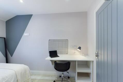 A bright and clean bedroom featuring a simple d...