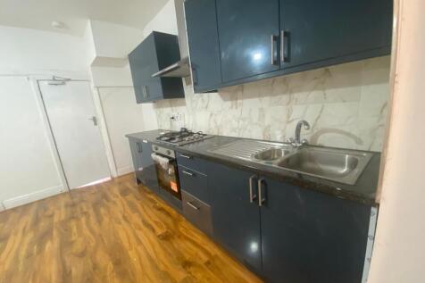 Modern kitchen featuring sleek dark cabinetry, ...