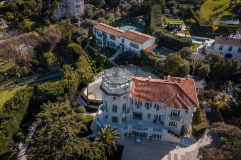 Aerial view of a large, elegant villa with a red-t